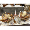 Decorative table setting with candles, pumpkins, and fall-themed decor on a floral tablecloth. Pumpkin and Oak Leaf Candle Ring and Floral Spray available at Quilted Cabin Home Decor.