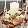 Decorative arrangement with a candle, pumpkins, and dried elements on a wooden tray. Pumpkin and Oak Leaf Candle Ring and Floral Spray available at Quilted Cabin Home Decor.