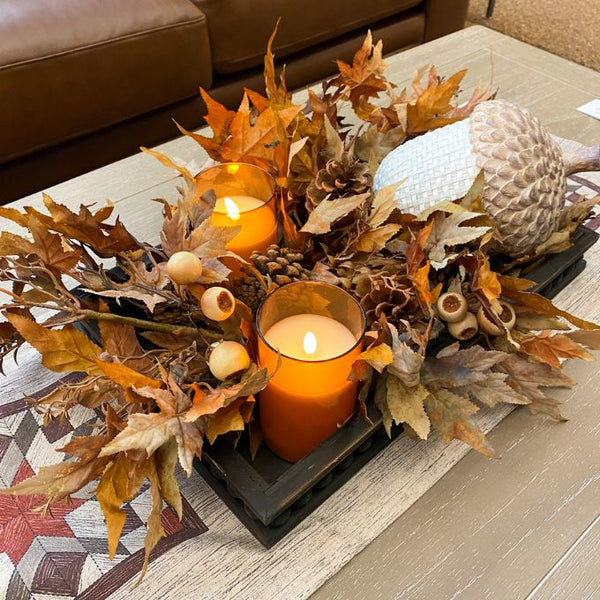Decorative fall arrangement with candles and leaves on a coffee table. Earthy Maple Floral Spray available at Quilted Cabin Home Decor.