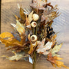 Autumn-themed floral arrangement with leaves, acorns, and pinecones on a wooden surface. Earthy Maple Floral Spray available at Quilted Cabin Home Decor.