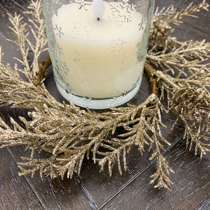 Decorative candle with gold candle wreath on a wooden surface. Golden Candle Ring/Small Wreath available at Quilted Cabin Home Decor.