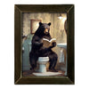 Framed artwork of a bear reading a book on a toilet in a bathroom setting available at Quilted Cabin in Airdrie