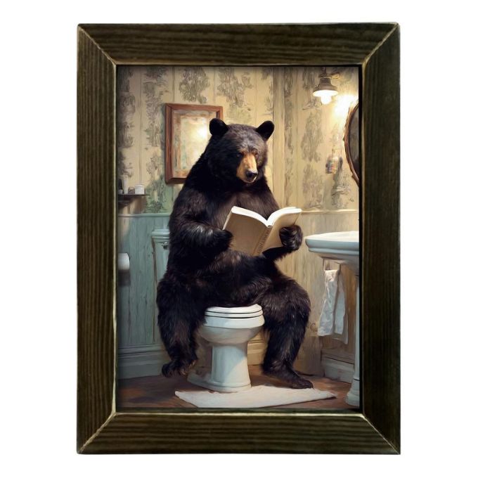 Framed artwork of a bear reading a book on a toilet in a bathroom setting available at Quilted Cabin in Airdrie
