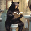 Framed artwork of a bear reading a book on a toilet in a bathroom setting available at Quilted Cabin in Airdrie
