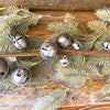 seven silver traditional style jingle bells attached to slim floral wires to add into floral displays or use in centerpieces. Available at Quilted Cabin Home Decor.