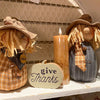 A cinnamon coloured votive candle with fall decor available at Quilted Cabin Home Decor.