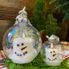 Two sizes of a snowman LED Candle in a clear plastic ornament. Available at Quilted Cabin Home Decor.