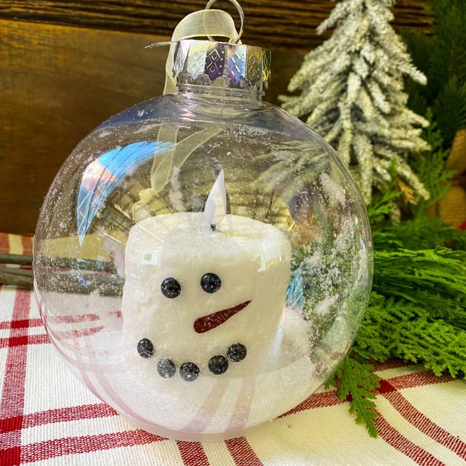 Two sizes of a snowman LED Candle in a clear plastic ornament. Available at Quilted Cabin Home Decor.