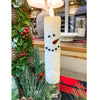 Decorative candle shaped like a snowman with greenery and a blurred indoor background. Snowman LED Taper Timer Candle available at Quilted Cabin Home Decor.