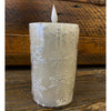 Frosted candle with snowflake patterns on a wooden surface.  White Snowflake LED 5" Pillar Candle available at Quilted Cabin Home Decor.