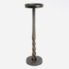 A rustic metal pedestal candle holder with a twisted spiral stem, a circular top cup, and a round base, shown against a plain light gray background. Comes in two sizes available at Quilted Cabin in Airdrie