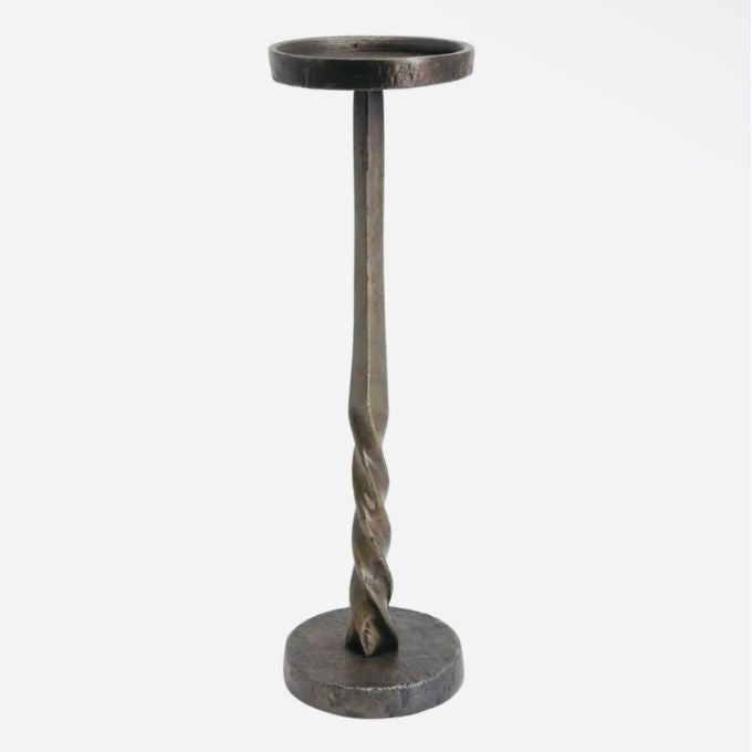 A rustic metal pedestal candle holder with a twisted spiral stem, a circular top cup, and a round base, shown against a plain light gray background. Comes in two sizes available at Quilted Cabin in Airdrie