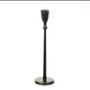 A single black metal candlestick holder with a long stem, a flared top cup, and a round base, shown against a plain white background.  Candle holder comes in two sizes available at Quilted Cabin in Airdrie