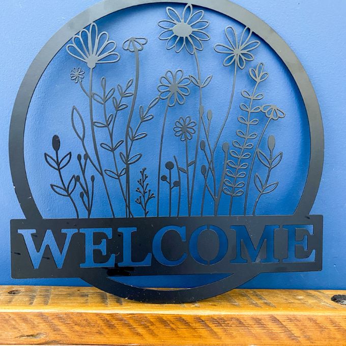 Welcome Wildflower Metal Hanger available at Quilted Cabin Home Decor.