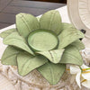 Decorative green metal shaped flower on a textured surface.  Green Floral Tin Candle Holder available at Quilted Cabin Home Decor.