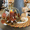 Decorative centerpiece with candle, leaves, and fox figurine. Gold Pumpkin Lantern available at Quilted Cabin Home Decor.