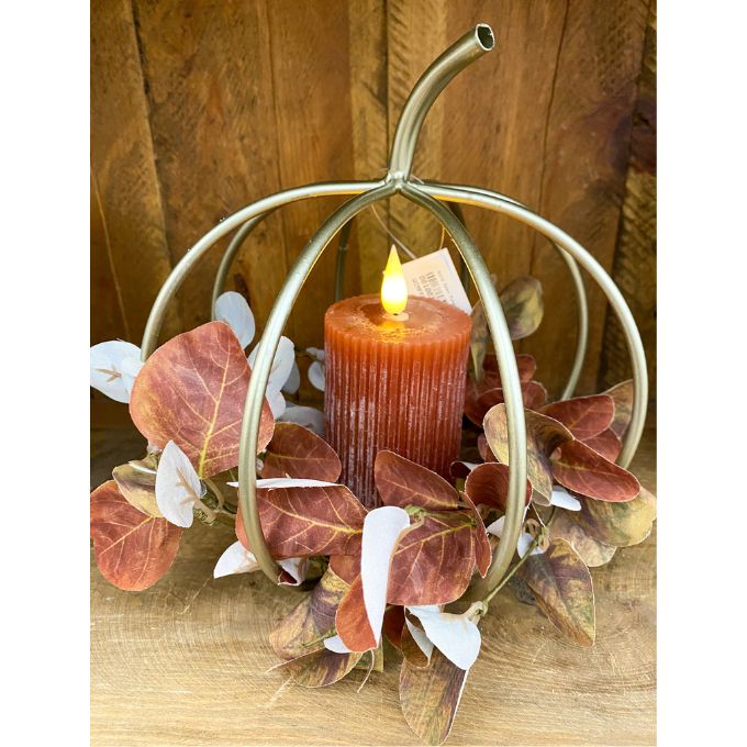 Decorative pumpkin-shaped candle holder with a lit candle and autumn leaves. Gold Pumpkin Lantern available at Quilted Cabin Home Decor.