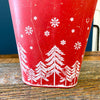 Red & White Tree Wall Bucket is a tall red metal bucket with white christmas trees and snowflakes along the bottom of it. Available at Quilted Cabin Home Decor.