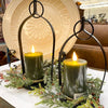 Two lit candles in decorative holders with greenery on a table. Black Metal Open Lanterns - Set of Two available at Quilted Cabin Home Decor.