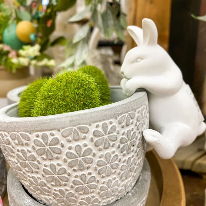 Decorative pot with green moss and a white ceramic rabbit pot hanger. Porcelain Bunny Pot Hanger available at Quilted Cabin Home Decor.