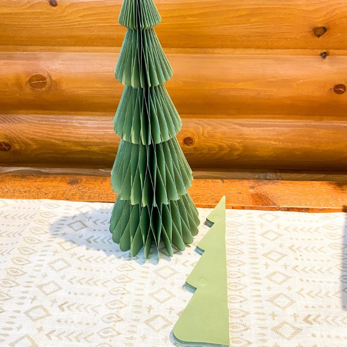 Green paper Christmas tree on a textured surface with wooden background. Vintage Green Paper Trees - Two Sizes available at Quilted Cabin Home Decor.