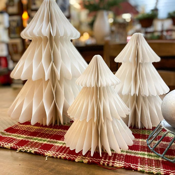 Three paper trees on a striped tablecloth with a blurred indoor background. Vintage White Paper Trees - Three Sizes available at Quilted Cabin Home Decor.
