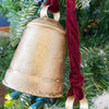 Three gold cow bells hang from a red velvet rope and makes a lovely decoration. Available at Quilted Cabin Home Decor.