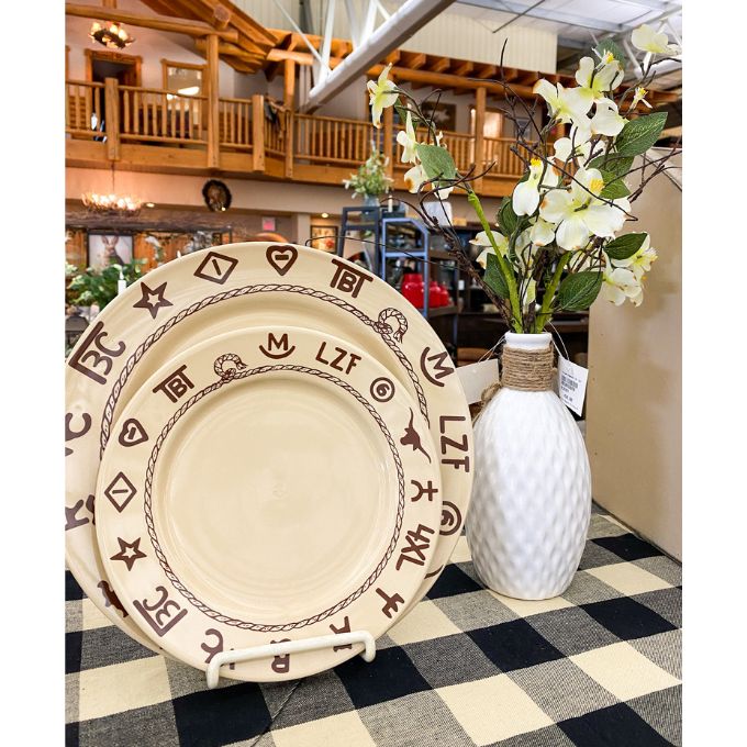 Decorative plates with patterns next to a white vase with flowers on a checkered table runner. Porcelain Textured Vase available at Quilted Cabin Home Decor.