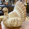 Decorative resin turkey figure on a wooden surface with a blurred indoor background. Weathered Resin Turkey available at Quilted Cabin Home Decor.