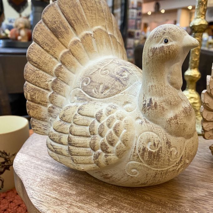 Decorative resin turkey decor on a wooden surface. Weathered Resin Turkey available at Quilted Cabin Home Decor.