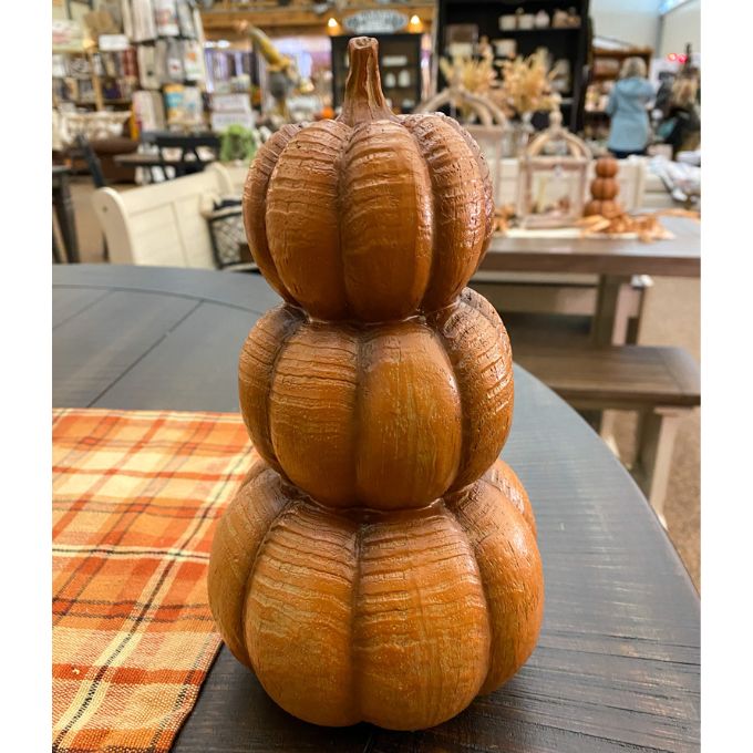 A Three Stack pumpkin in a deep orange color is shown with other fall decor items. Available at Quilted Cabin Home Decor.