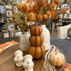 A Three Stack pumpkin in a deep orange color is shown with other fall decor items. Available at Quilted Cabin Home Decor.