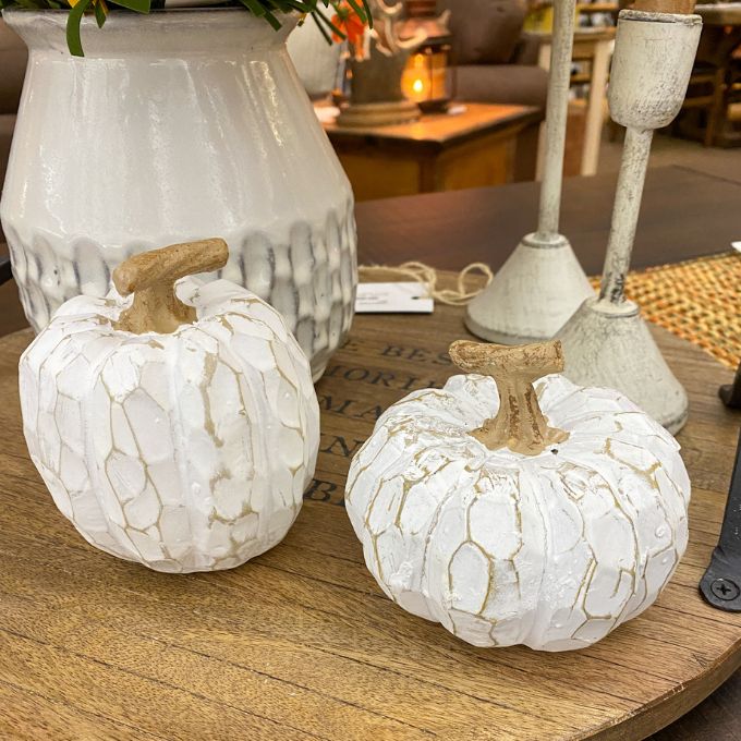 Two white marbled pumpkins on a wooden surface with a blurred indoor background. White Carved Pumpkins - Two Styles available at Quilted Cabin Home Decor.