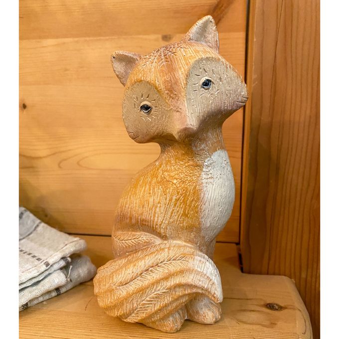 A tan fox figurine with a white chest and white tipped tail is available at Quilted Cabin Home Decor.