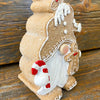 Gingerbread gnome figurine has a full beard and is holding a candy cane and gingerbread man. It is available at Quilted Cabin Home Decor.