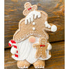 Gingerbread gnome figurine has a full beard and is holding a candy cane and gingerbread man. It is available at Quilted Cabin Home Decor.