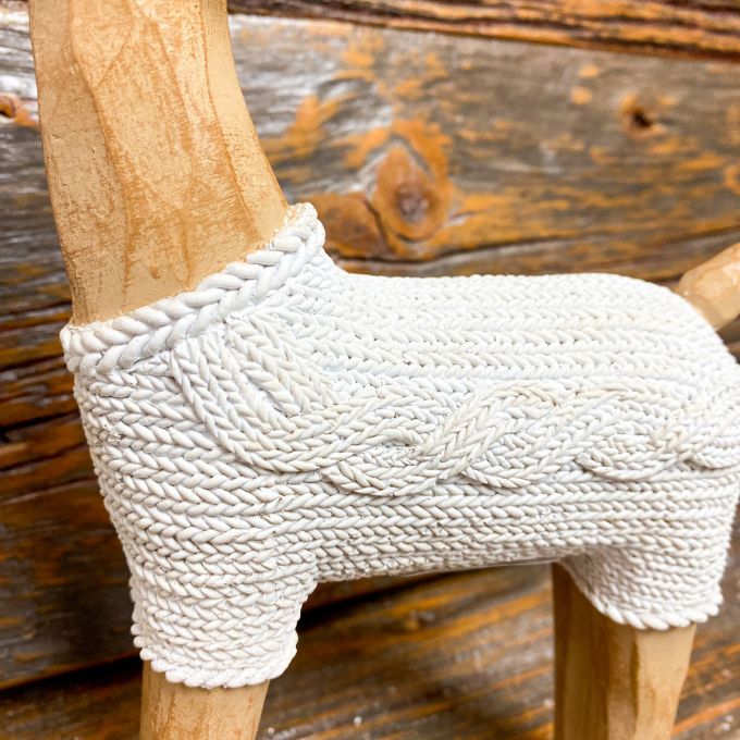 One resin standing deer figurine wearing a white cable knit sweaters is shown.  Available at Quilted Cabin Home Decor.