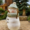 Decorative snowman figurine with a green hat and scarf. Green Hat Snowman Figurine available at Quilted Cabin Home Decor.