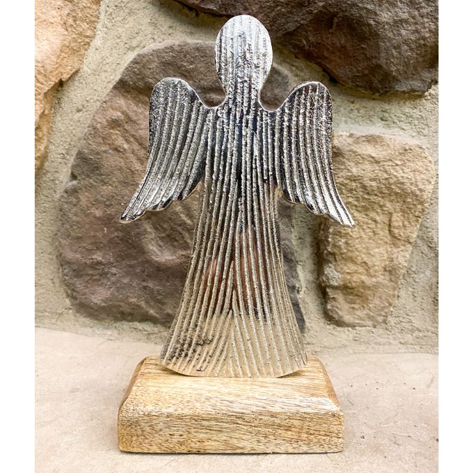 Metal angel sculpture on a wooden base against a stone wall background. Midnight Shimmer Angels - Two Sizes available at Quilted Cabin Home Decor.