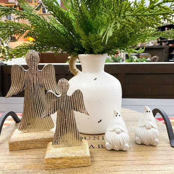 Decorative angel figures and gnome statues on a wooden surface with a vase in the background. Midnight Shimmer Angels - Two Sizes available at Quilted Cabin Home Decor.