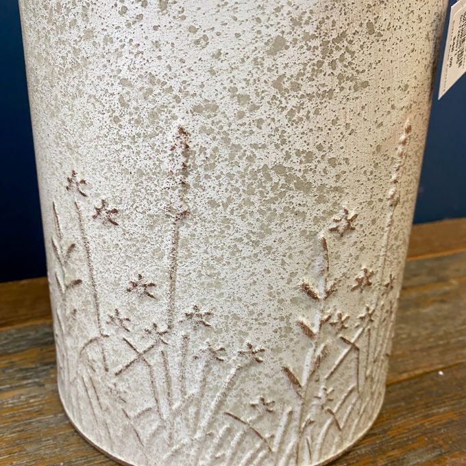 Textured ceramic vase with embossed designs on a wooden surface. Embossed Metal Milk Cans - Two Colours available at Quilted Cabin Home Decor.