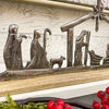 Metal nativity scene with wooden border on a rustic background. Nativity Silhouette available at Quilted Cabin Home Decor.