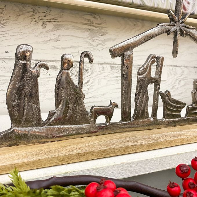 Metal nativity scene with wooden border on a rustic background. Nativity Silhouette available at Quilted Cabin Home Decor.