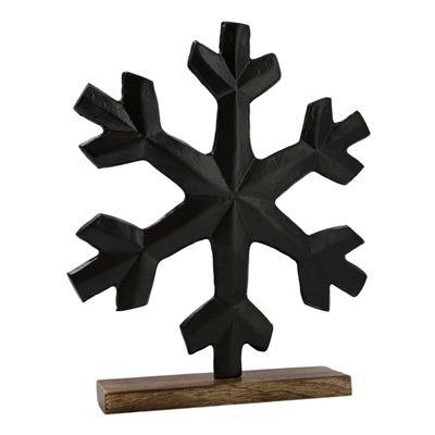Black metal snowflake on a wooden base.  Makes a great statement piece available at Quilted Cabin in Airdrie
