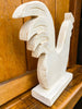 White stone sculpture of a rooster on a wooden surface. Whitewashed Wooden Hen on Stand available at Quilted Cabin  Home Decor. 