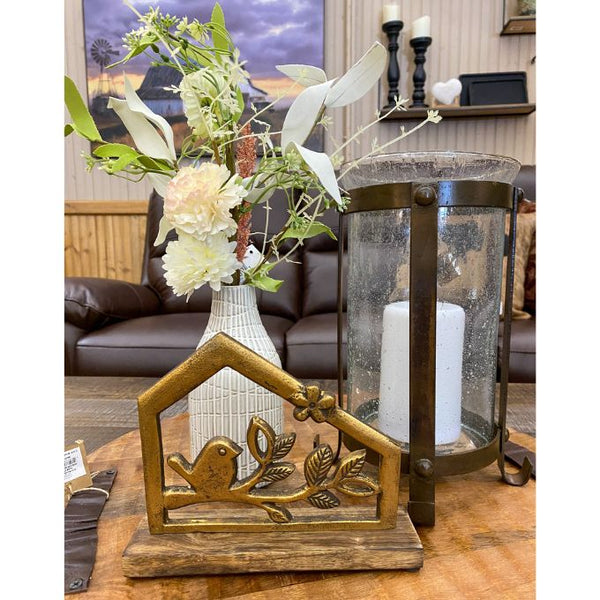 Decorative items including a lantern, vase with flowers, and decorative piece on a table. Bird and Branch Hut Stands - Two Sizes available at Quilted Cabin Home Decor.