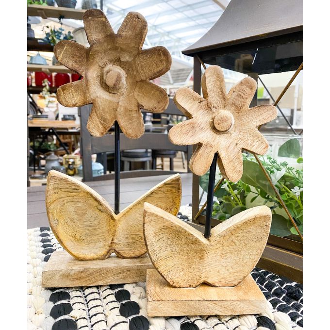 Wooden flower decor on a table with a blurred background. Wooden Daisies on Stand - Set of Two available at Quilted Cabin Home Decor.
