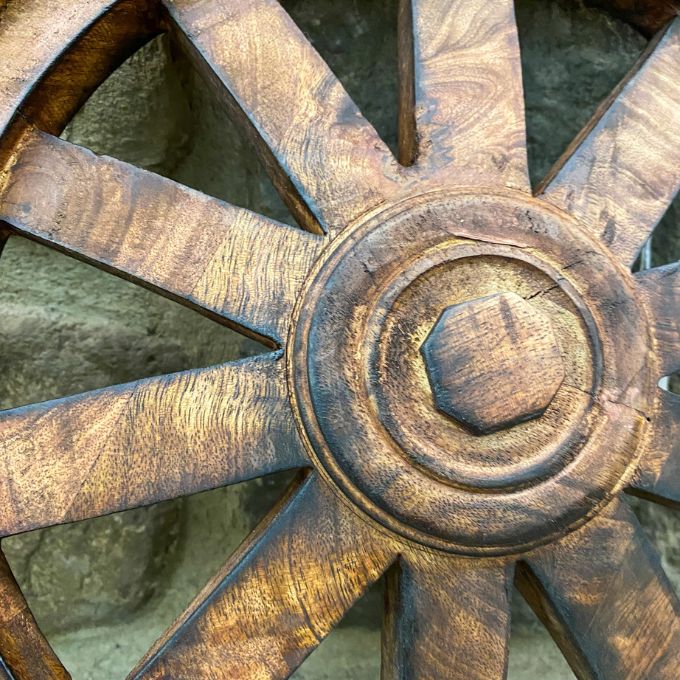 Close-up of a wooden wagon wheel with a rustic finish. Wooden Wagon Wheels - Two Sizes available at Quilted Cabin  Home Decor.