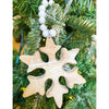 White distressed wooden snowflake ornaments in two different styles on white beaded hangers available at Quilted Cabin Home Decor.