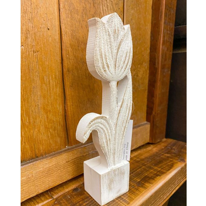 Carved wooden tulip sculpture on a wooden surface. Whitewashed Wooden Flowers - Three Styles available at Quilted Cabin Home Decor.